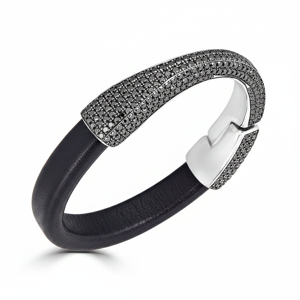 A black leather cuff bracelet with a sterling silver clasp and pavé-set natural black diamonds on the front, shown on a clean white background.