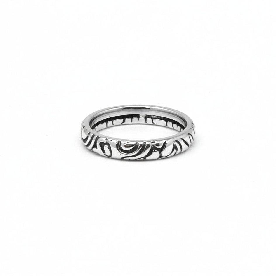 Silver ring with intricate design on a white background