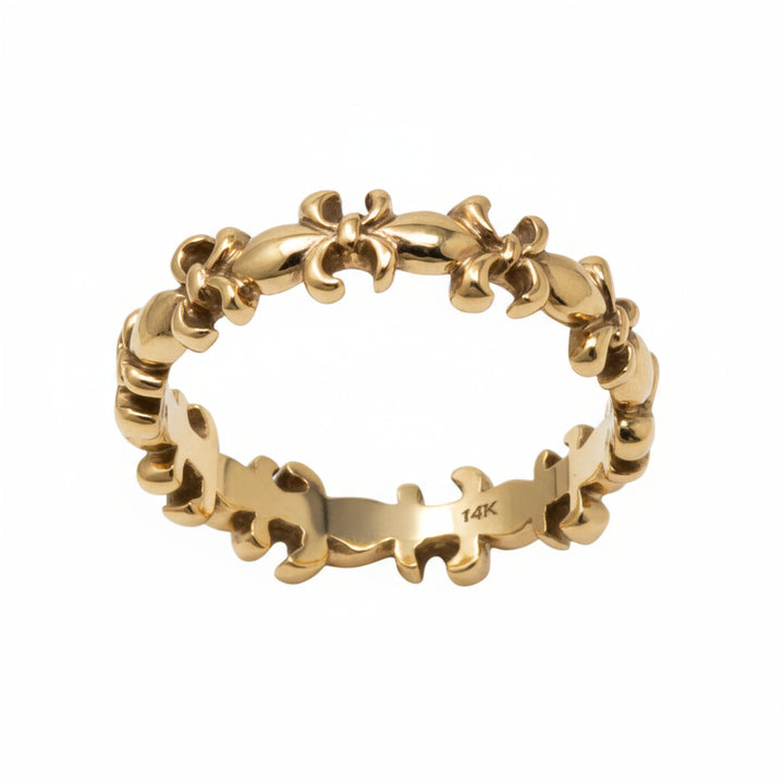 A gold band ring featuring fleur-de-lis symbols.