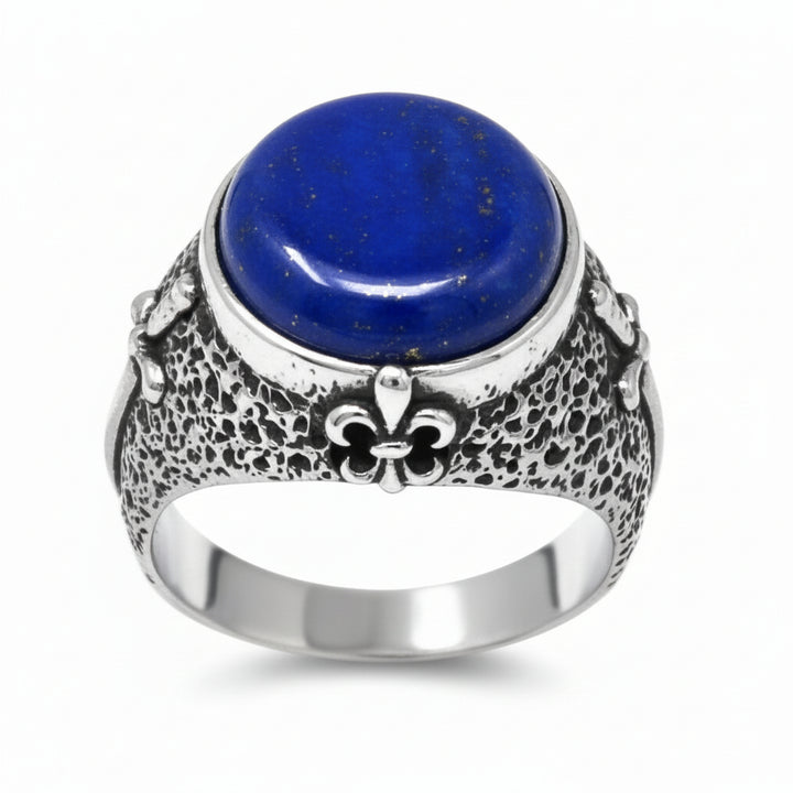 Silver ring with a red gemstone and fleur-de-lis design on a white background