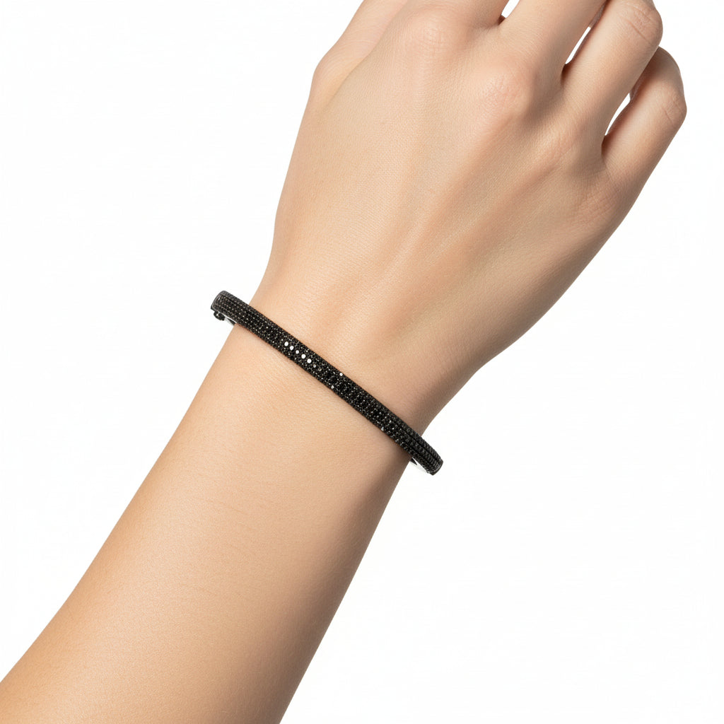 Black diamond bangle braclet on a wrist against a white background
