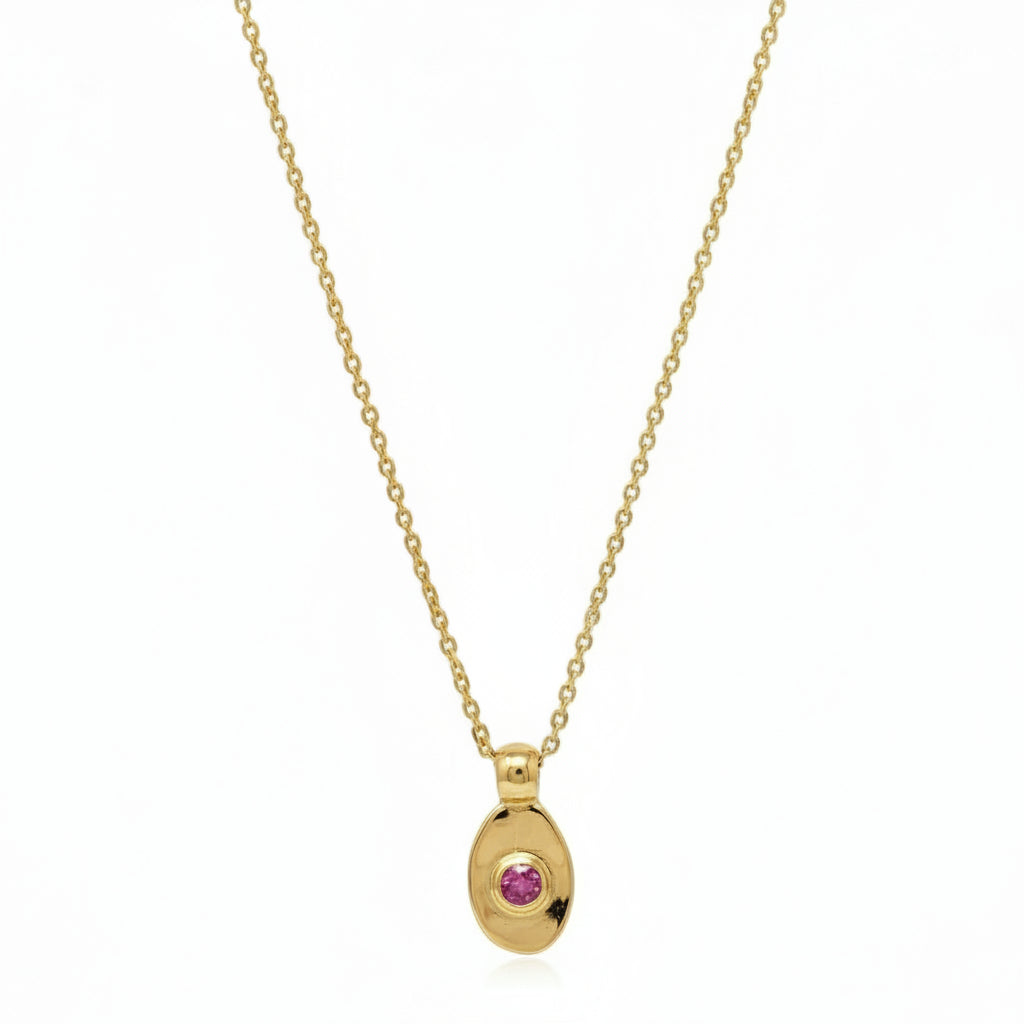 Gold necklace with a pink gemstone pendant on a white background