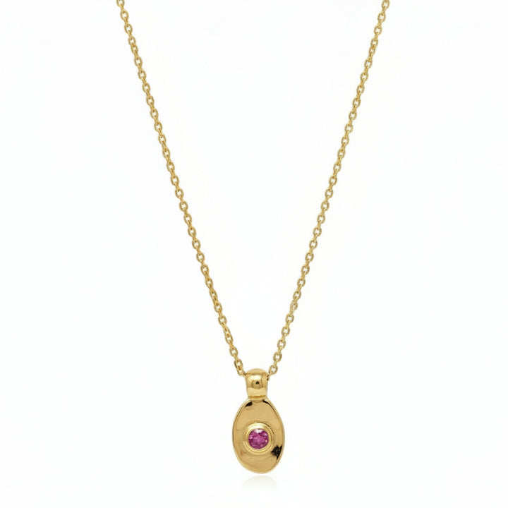 Gold necklace with a pink gemstone pendant on a white background